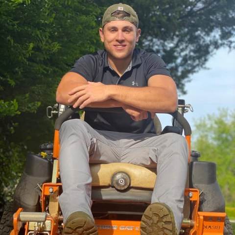 ALX Lawn Care operator sitting on a zero-turn mower